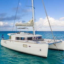 Cayman Adventure Tours departure point - white sailing catamaran anchored in calm clear turquoise water